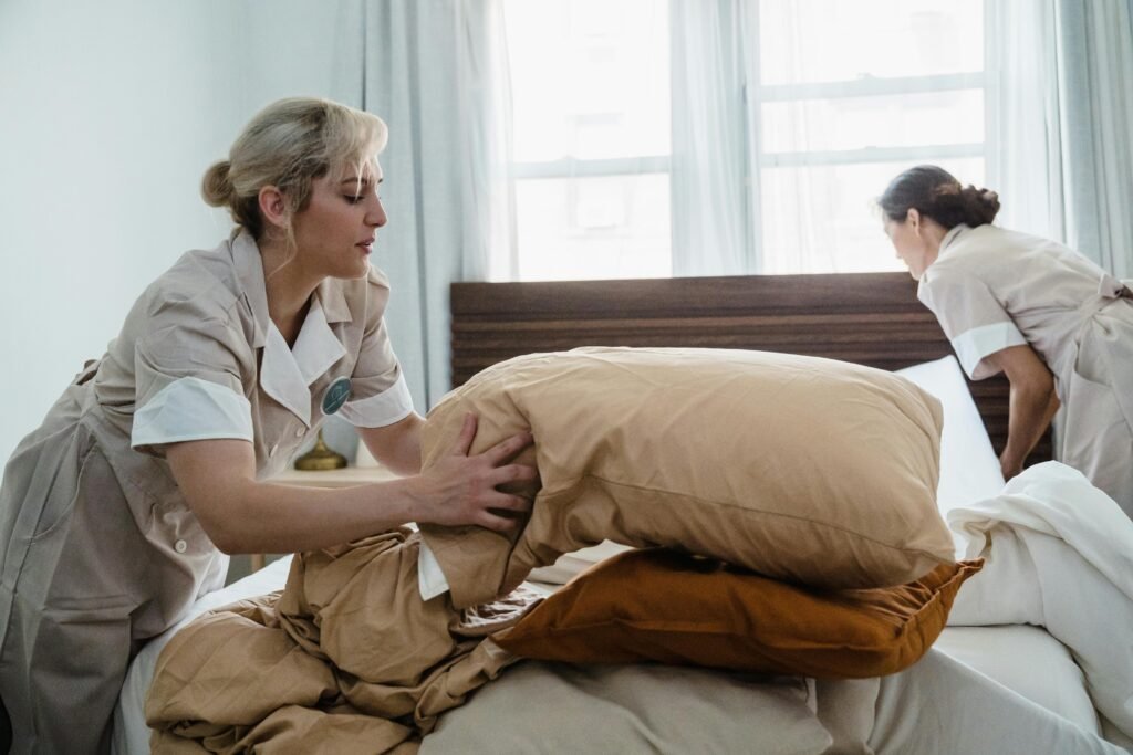 Miami House Cleaning Maids housekeeping staff efficiently clean and arrange a guest room bed.